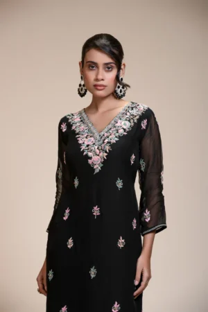 Front close-up of a black organza kurta with pastel floral embroidery, V-neckline, and sheer three-quarter sleeves.