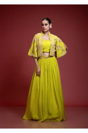 A woman posing in a vibrant Lime Green Skirt Set featuring a floral embroidered crop jacket with three-quarter length bell sleeves.
