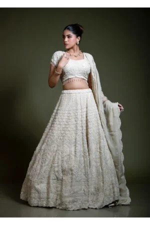 Ivory embroidered lehenga set with short sleeve blouse and dupatta in three-quarter standing pose